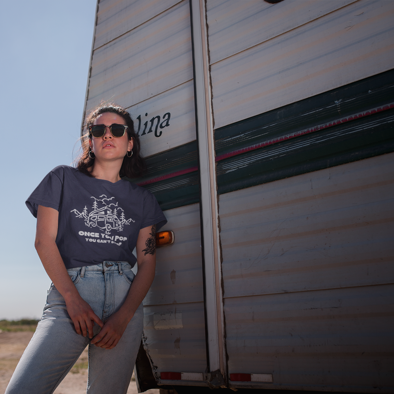 Person standing next to a trailer with a clear sky background
