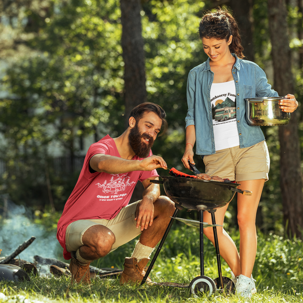 Two people and a dog enjoying a barbecue in a forest setting