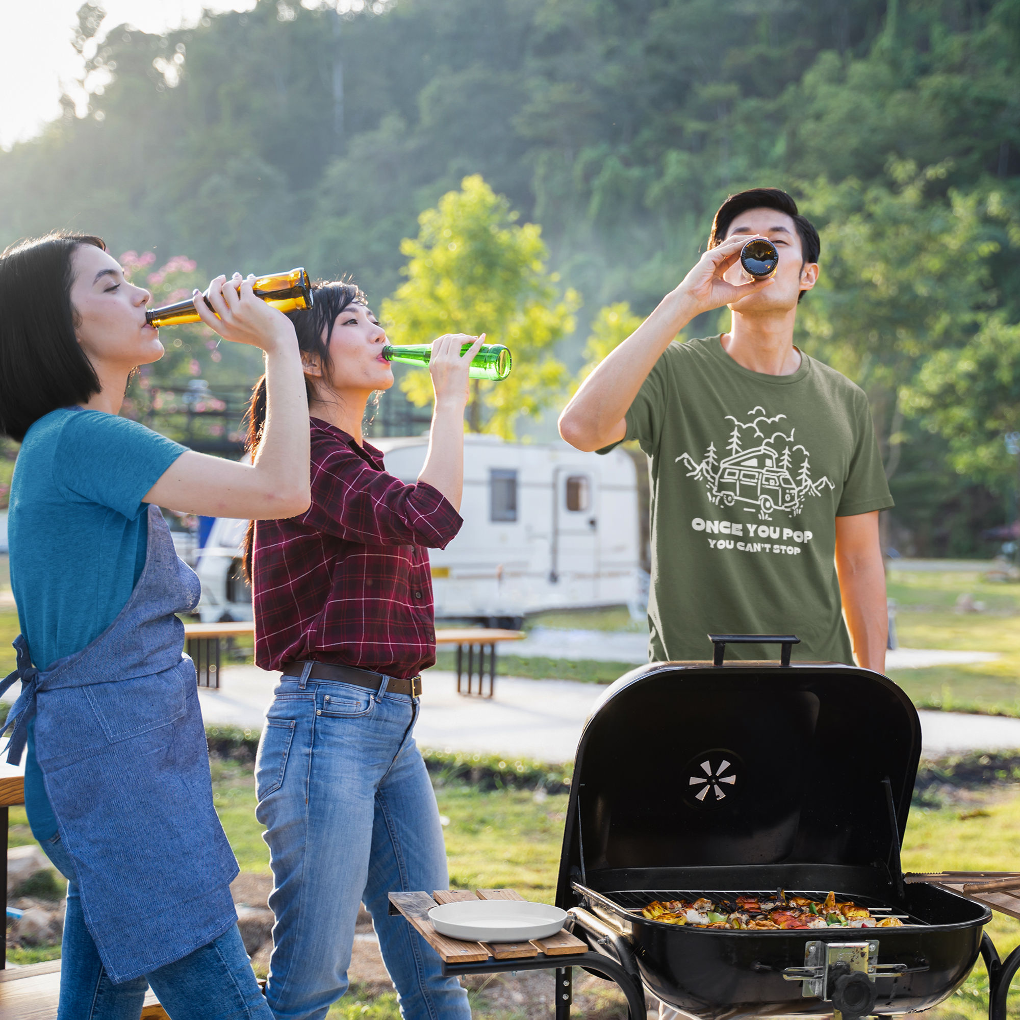 Four people enjoying drinks around a barbecue grill outdoors.